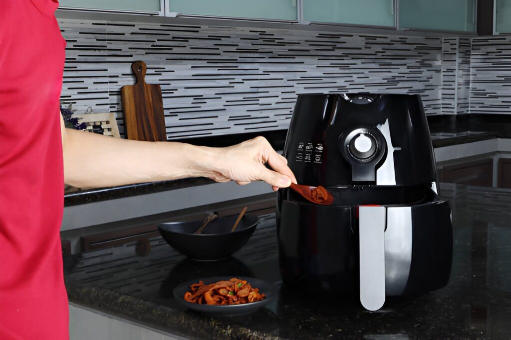 Friteuse Ninja Air Fryer posée sur un plan de cuisine, contenant des frites croustillantes et des légumes grillés.